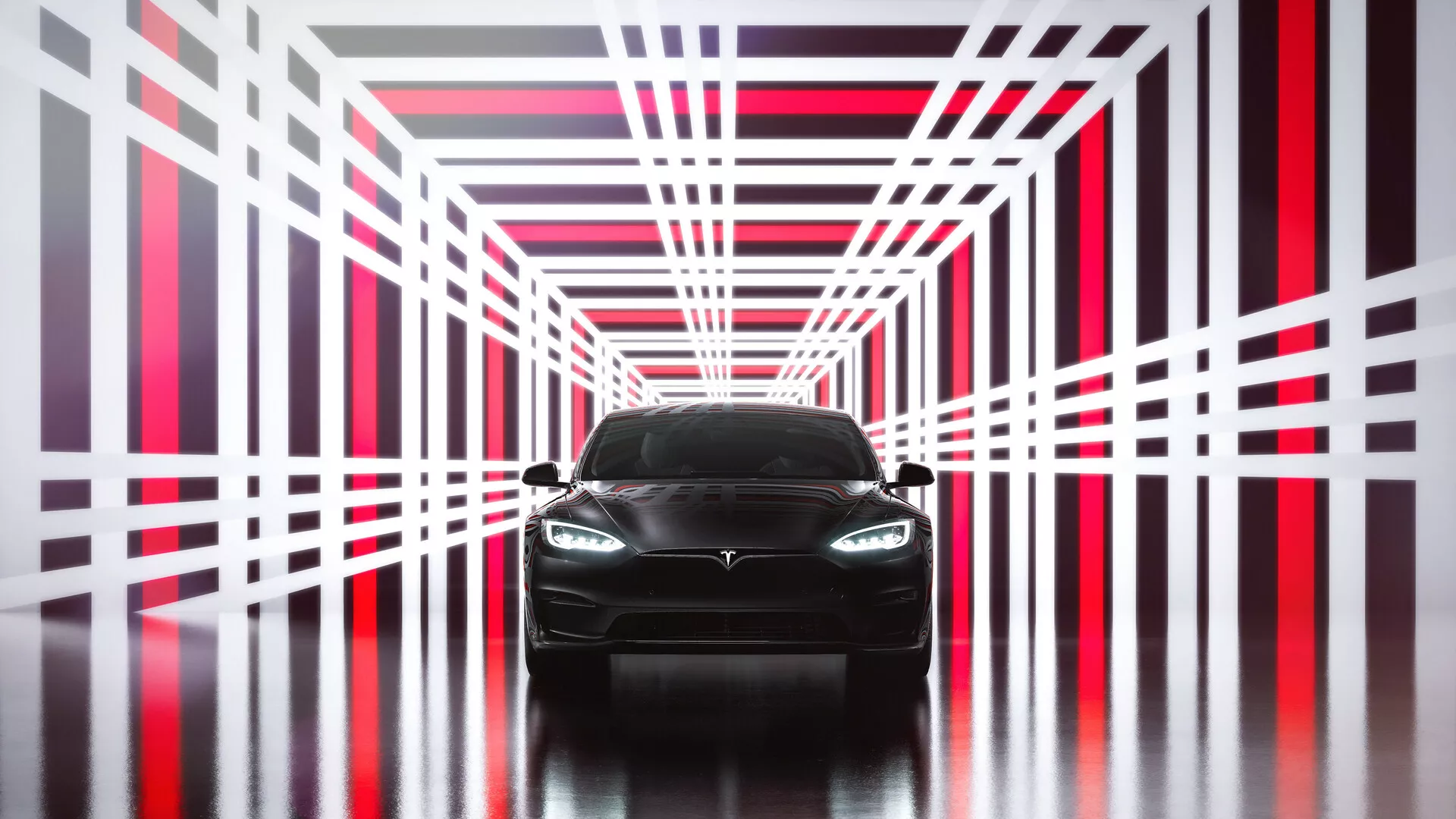 Vue de face d'une Tesla Model S 2016, première génération restylée. L'image met en avant le design moderne et élégant avec une façade avant agressive, arborant un emblème bien visible sur la grille, des phares LED ou HID modernes, et des contours lisses du capot. Le pare-chocs inférieur suggère un caractère sportif avec des prises d'air, tandis que la voiture repose sur une surface réfléchissante dans une structure futuriste de type tunnel avec des lumières néon rouges et blanches vives. La vue symétrique directe accentue le design et la symétrie, ce qui en fait un choix parfait pour les supports marketing automobiles.