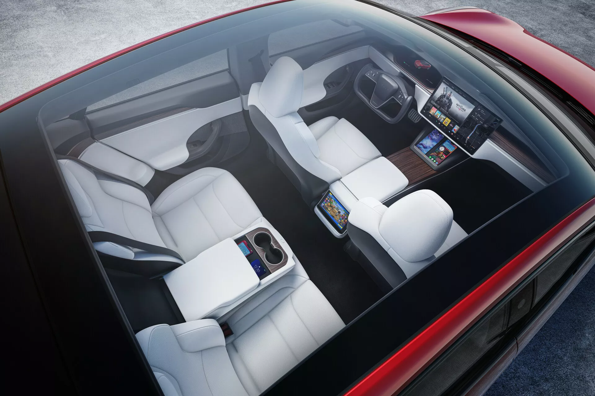 Vue plongeante de l'intérieur de la Tesla Model S 2016 (1ère génération, restylée). Présente des sièges rembourrés en blanc avec des contours individuels, un grand écran tactile central sur le tableau de bord avant, un tableau de bord numérique, une console centrale minimaliste et un accoudoir rabattable à l'arrière. Montre une technologie avancée, un design ergonomique et un luxe moderne.