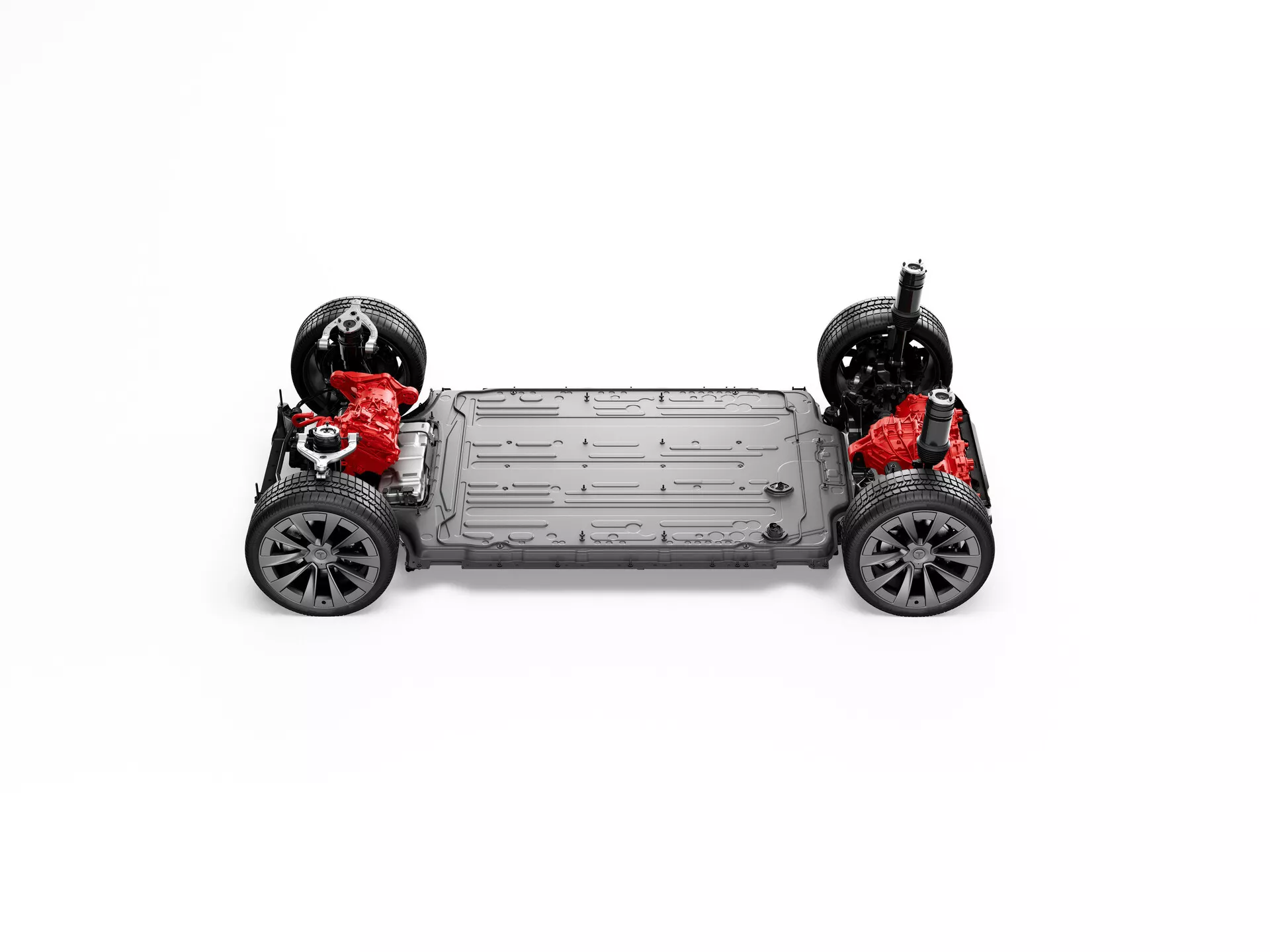Vue de dessus du châssis de la Tesla Model X 2021 (première génération restylée), affichant la structure sous-jacente et les composants. Deux moteurs rouges indiquant une configuration à double moteur, une grande batterie grise entre les essieux et les roues attachées aux systèmes de suspension gris argenté sont visibles. L'image met en valeur le système de transmission intégrale, l'architecture du véhicule électrique et le design structurel de la voiture.