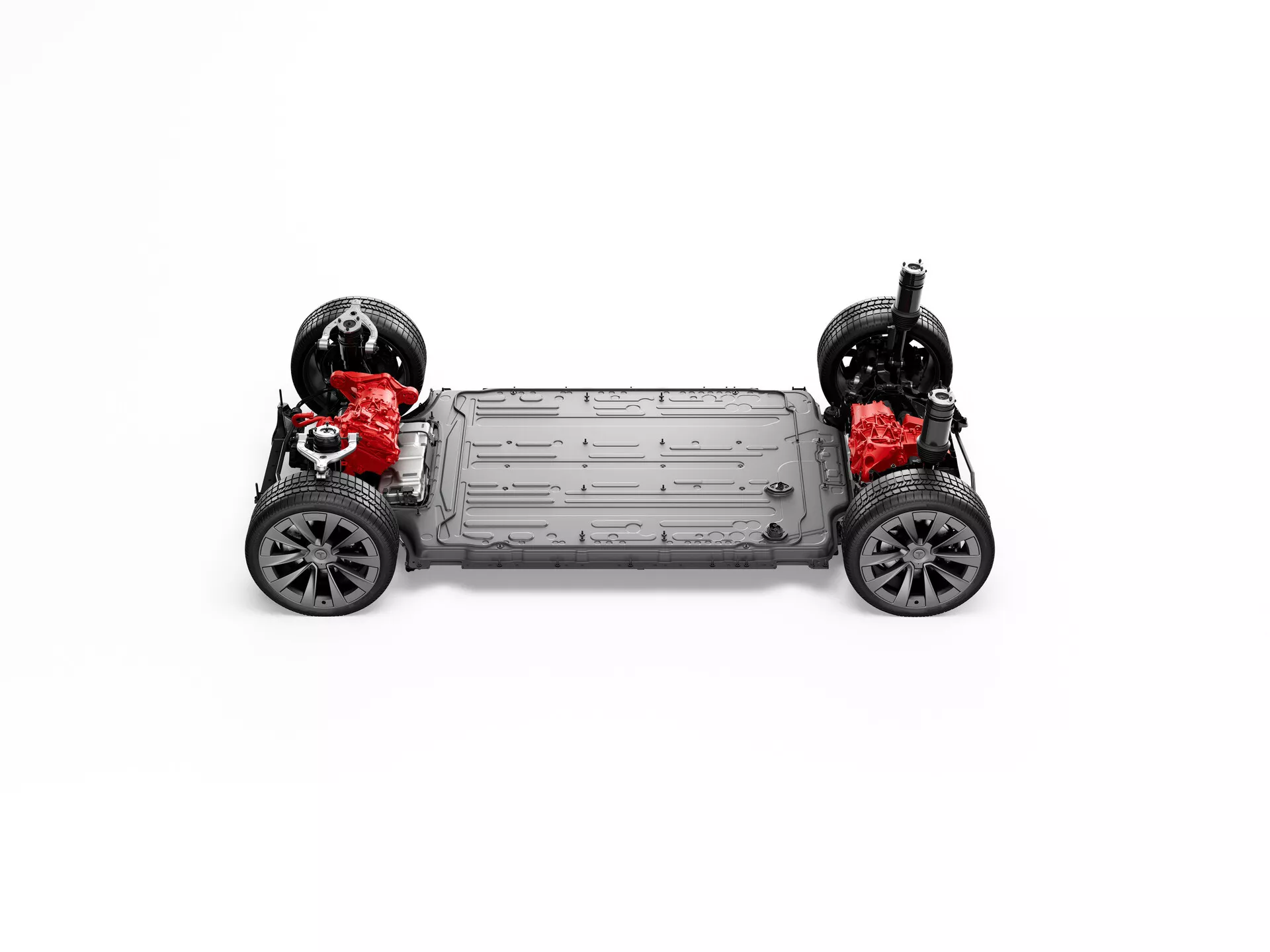 Vue de dessus du châssis de la Tesla Model-X 2021 (restylage de 1ère génération) sans carrosserie, montrant les roues avec bandes de roulement et grands disques de frein, le groupe motopropulseur à double moteur avec des composants rouges, le pack de batteries monté au centre, le cadre rigide avec longerons latéraux, le sous-carrosserie plat et la suspension indépendante avec amortisseurs rouges; placé sur un fond blanc.