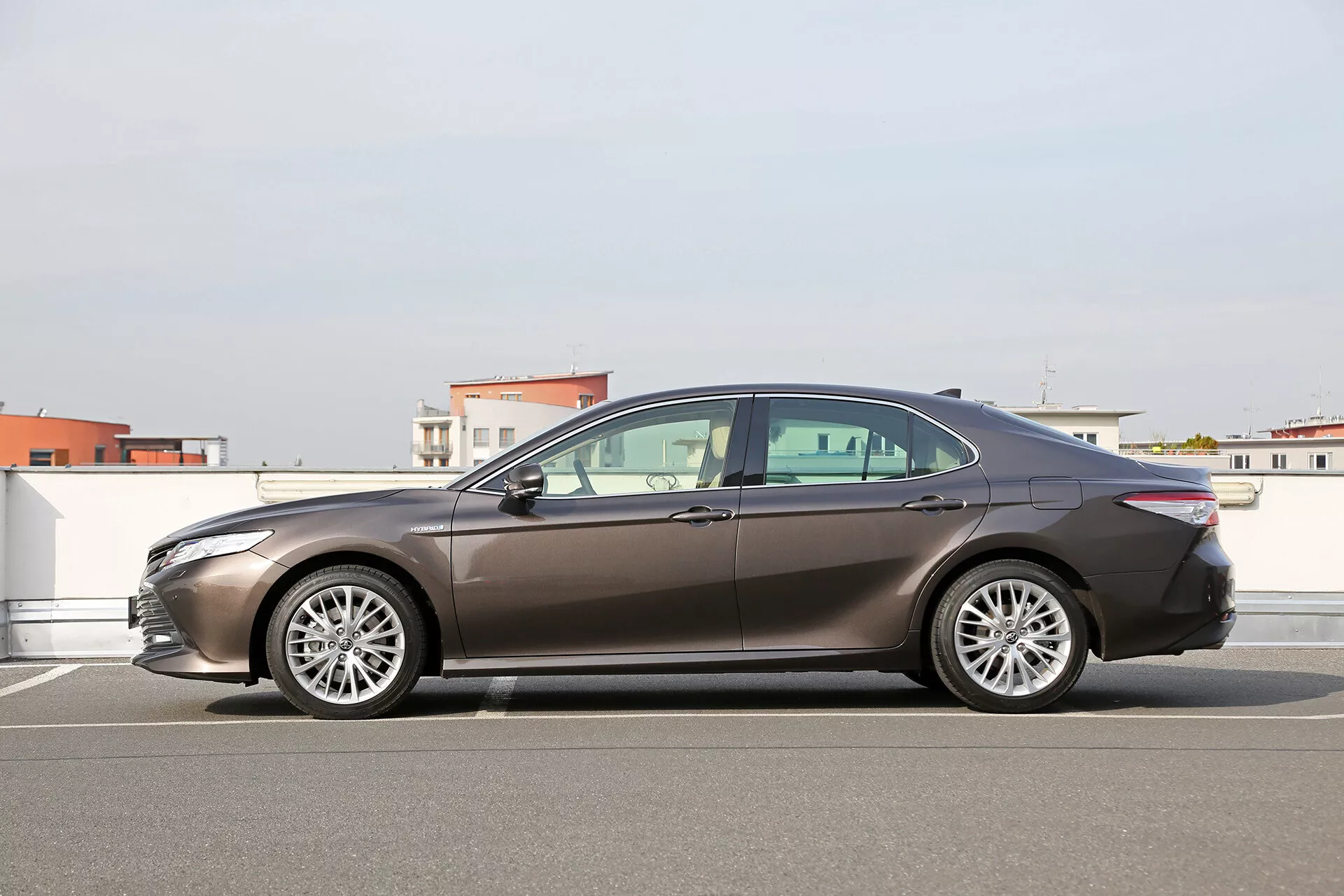 Vue latérale complète de la limousine Toyota Camry 2001 dans un parking à ciel ouvert avec design aérodynamique, phares LED et roues en alliage
