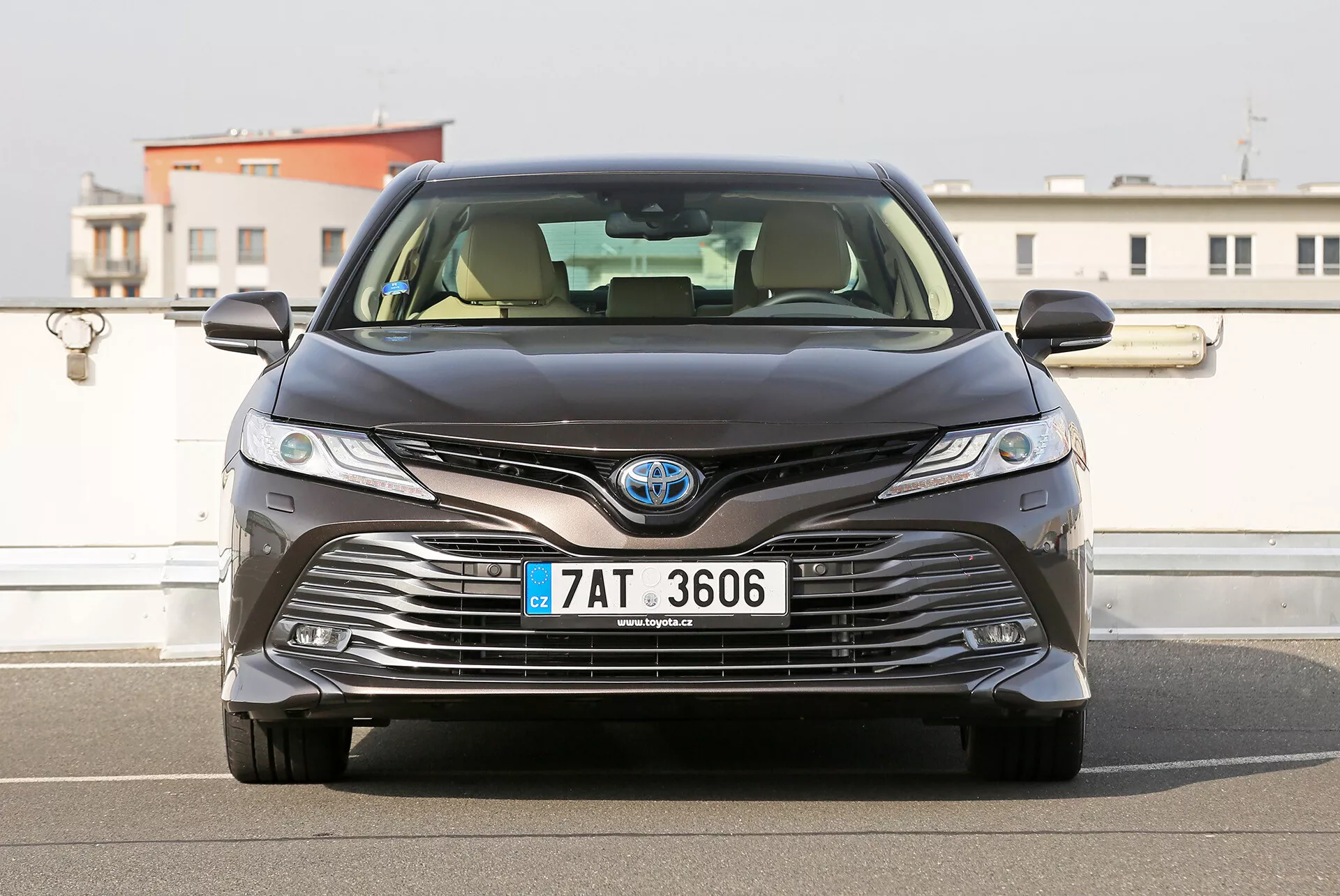 Vue de face de la limousine Toyota Camry 2001 montrant la grille, les phares LED et l'emblème de la technologie hybride, soulignant la conception avancée et les caractéristiques écologiques.
