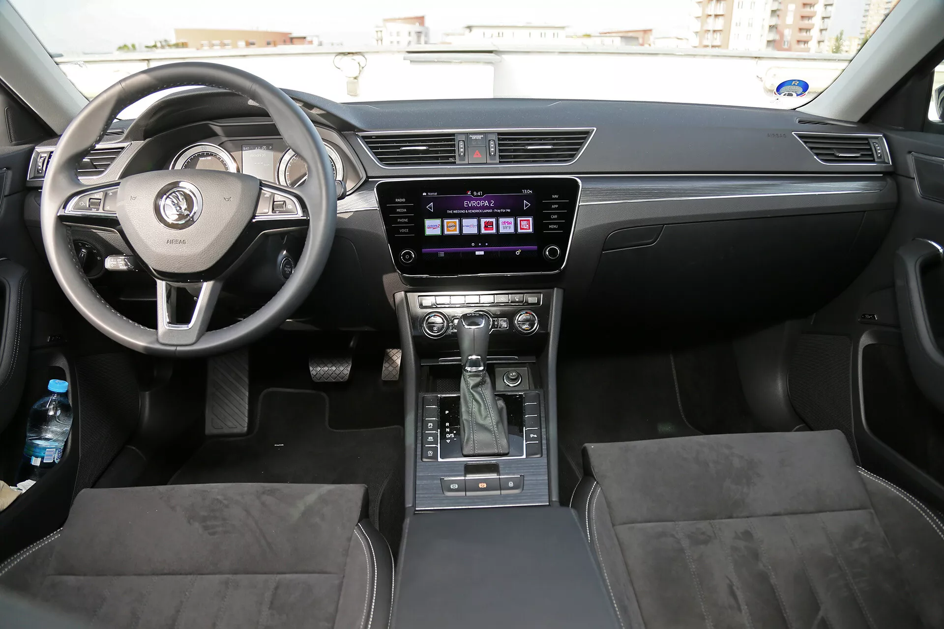 Intérieur de la limousine Toyota Camry 2001 mettant en vedette le tableau de bord, le volant à trois branches avec commandes intégrées, et la console centrale avec système d'infodivertissement et levier de vitesse automatique, accentué par un éclairage ambiant et naturel