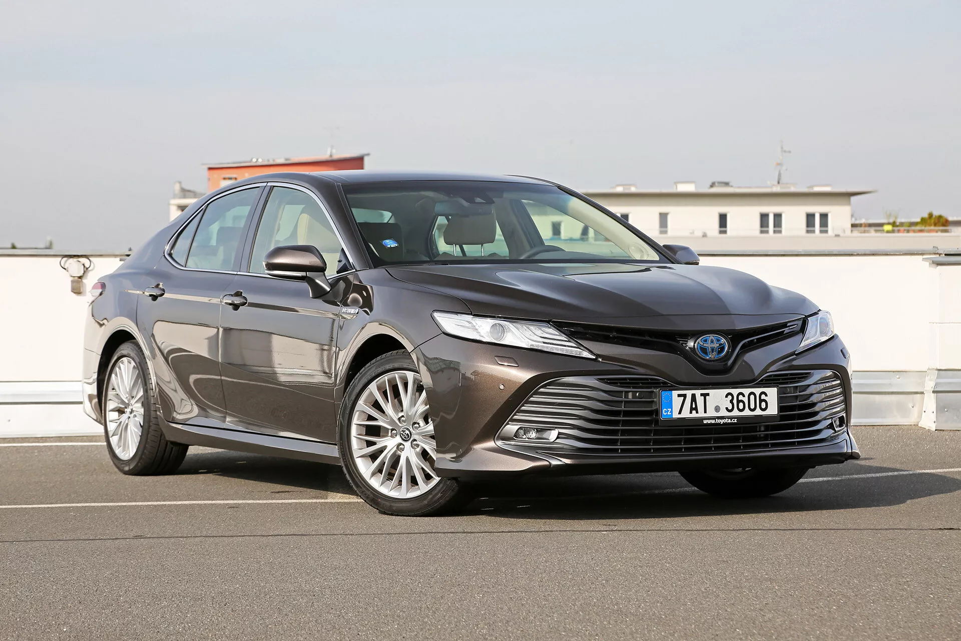 Image extérieure de la Toyota Camry Limousine 2019 montrant la grille avant grande et sophistiquée, les phares LED angulaires élégants, les jantes en alliage stylées et les fonctionnalités de sécurité avancées suggérant des capacités ADAS, capturées dans une finition métallique brillante.