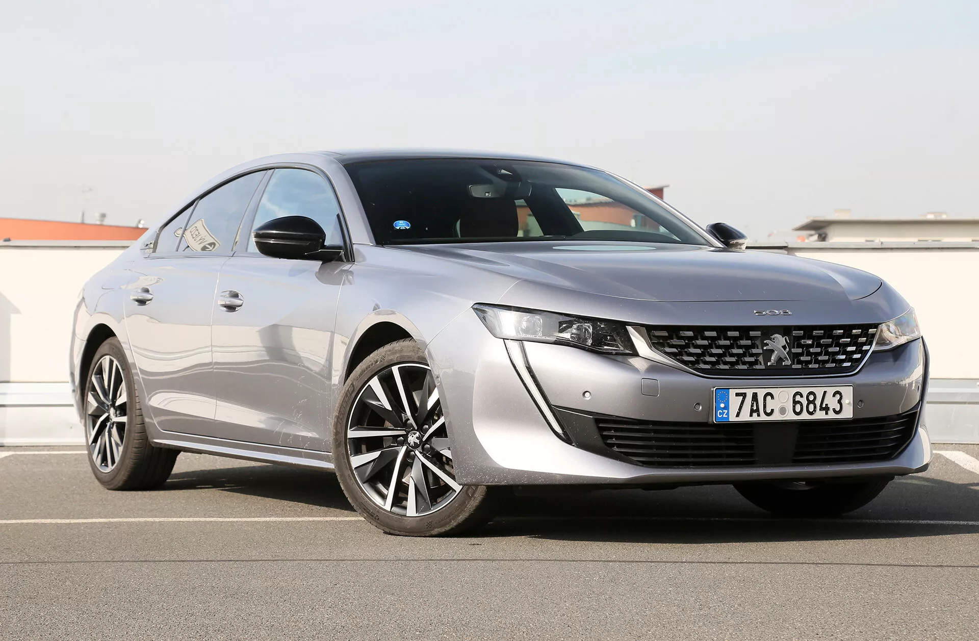 Toyota Camry Limousine 2019 vue sous un angle frontal de trois quarts mettant en évidence ses phares LED élégants, grille avant distinctive avec badge central, capot au design aérodynamique, et profil latéral avec grandes roues en alliage multi-rayons, peinture brillante, et ligne de toit façon coupé