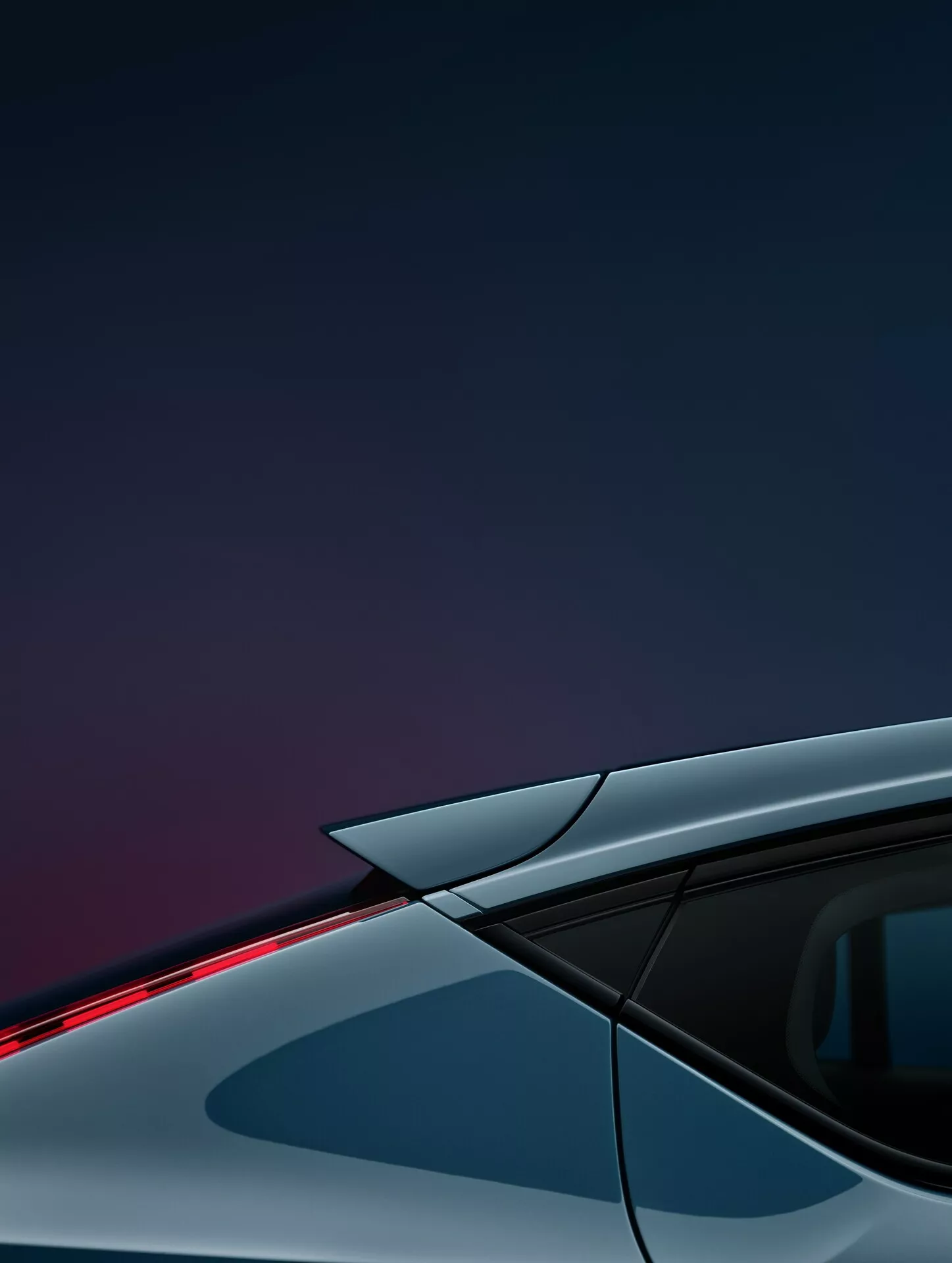 Détail en gros plan de la Volvo C40 2021 (1ère Génération) se focalisant sur le quart arrière supérieur du côté conducteur. L'image capture un angle arrière oblique mettant en avant la courbure aérodynamique du toit, la vitre latérale arrière et une bande lumineuse LED élégante au sommet du spoiler arrière. La photo incorpore une vitre teintée sombre avec un pilier visible, une carrosserie en métal argenté ou gris et un fond dégradé de bleu foncé à violet, mettant en valeur les caractéristiques de design avancées et l'esthétique moderne du véhicule.