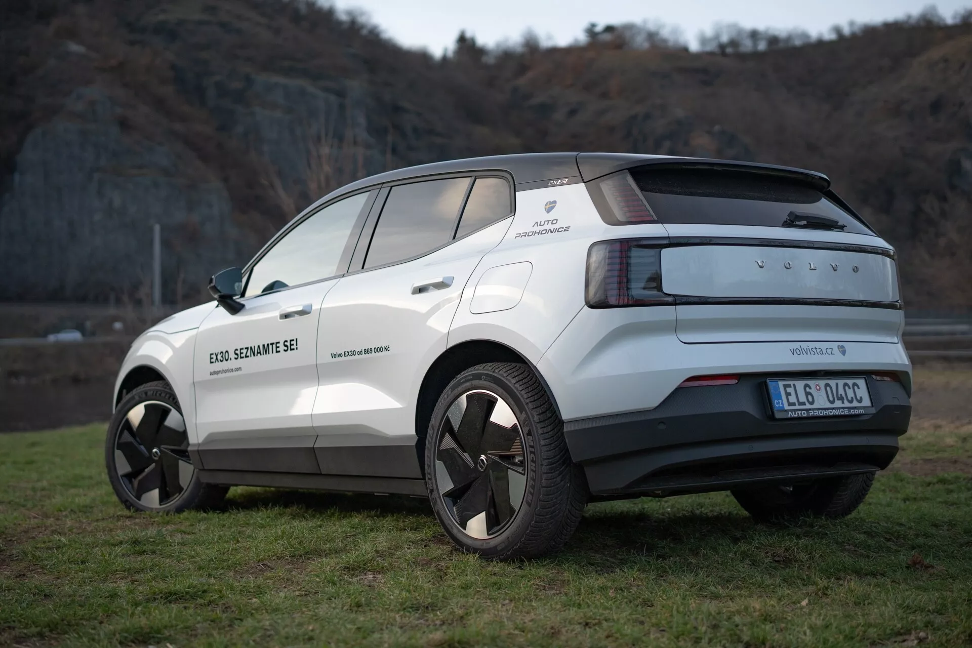 Vue arrière trois quarts du crossover électrique Volvo EX30 2024 en blanc, mettant en lumière son design moderne, ses jantes en alliage, ses capteurs de stationnement et ses fonctionnalités d'assistance au conducteur