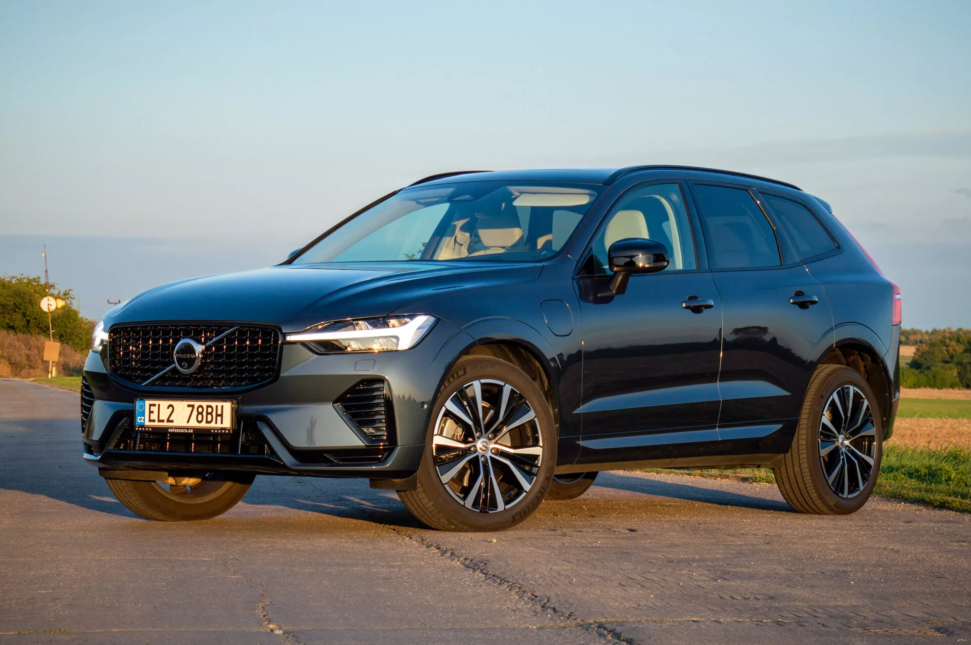 SUV Volvo XC60 Recharge Plug-In Hybrid 2021 en perspective avant trois-quarts présentant des phares LED, calandre élégante et jantes en alliage modernes sous la lumière naturelle du jour