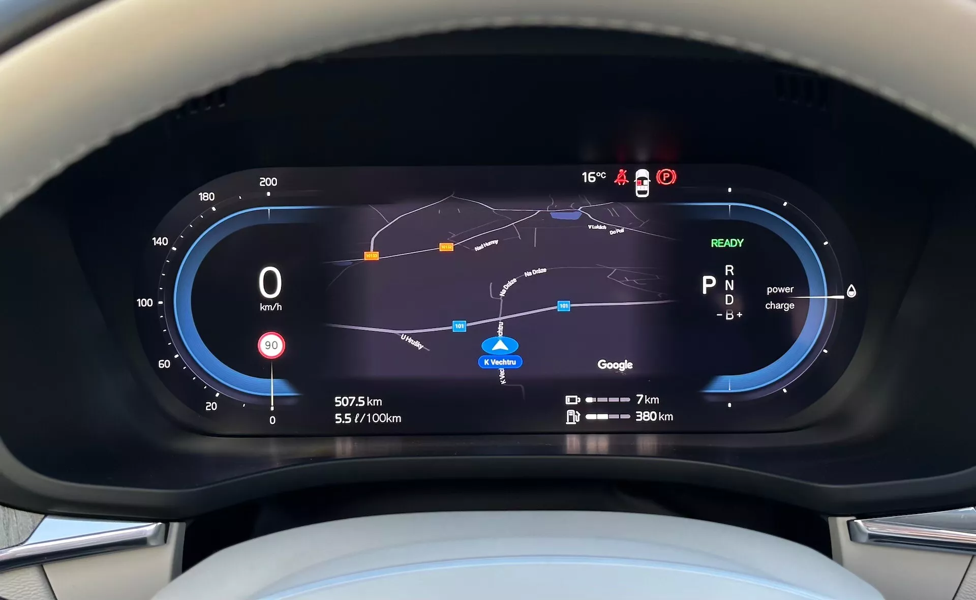 Vue du tableau de bord numérique du Volvo XC60 Recharge hybride branchable 2021 du point de vue du conducteur, affichant le compteur de vitesse, le jauge d'efficacité énergétique, l'utilisation de la puissance, la carte de navigation et divers indicateurs de conduite