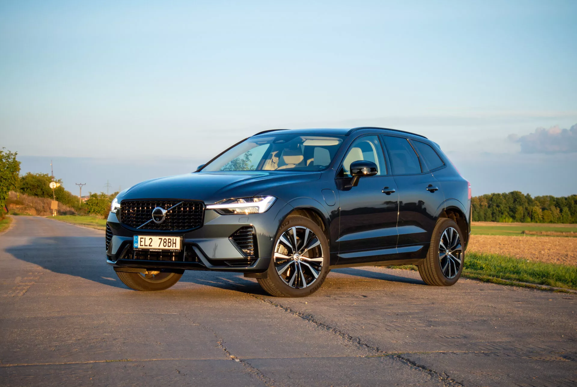 SUV de taille moyenne Volvo XC60 Recharge Plug-In Hybrid 2021 au design élégant et sportif, avec phares LED Thor's Hammer, roues en alliage avancées et calandre sculptée, capturé dans une lumière d'après-midi chaude depuis un angle avant de trois quarts montrant le profil latéral dynamique et la façade avant.