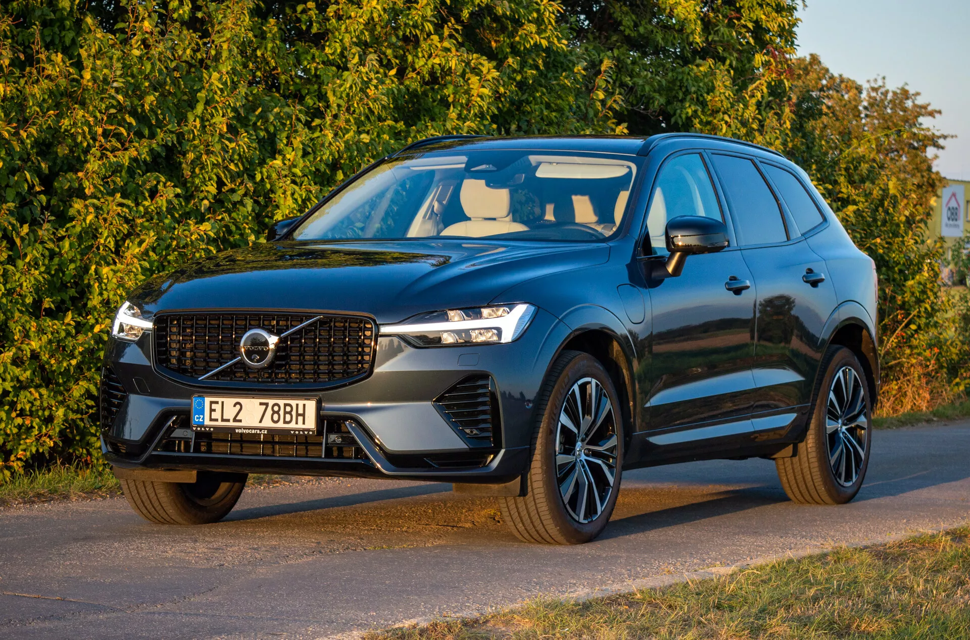 Volvo XC60 Recharge hybride rechargeable de 2021 de couleur foncée, vue de trois quarts avant montrant les phares LED, la grille emblématique, les jantes en alliage sportives et le design aérodynamique, garée en diagonale orientée vers la gauche avec un regard détaillé sur l'avant et le côté conducteur.