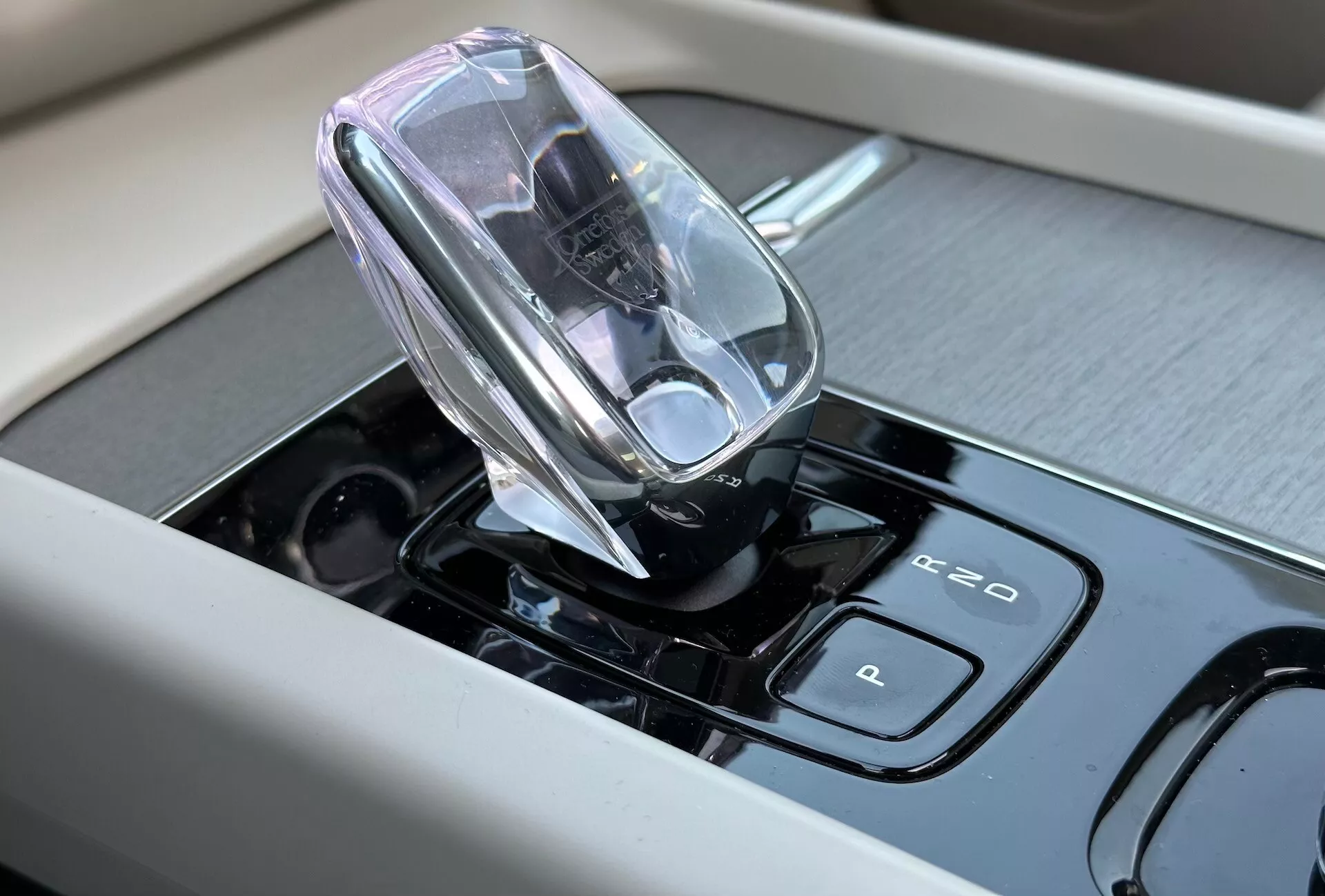 Vue rapprochée de l'intérieur du Volvo XC60 Recharge Plug-in Hybrid 2021 mettant en avant le sélecteur de vitesses électronique de haute technologie et les commandes tactiles