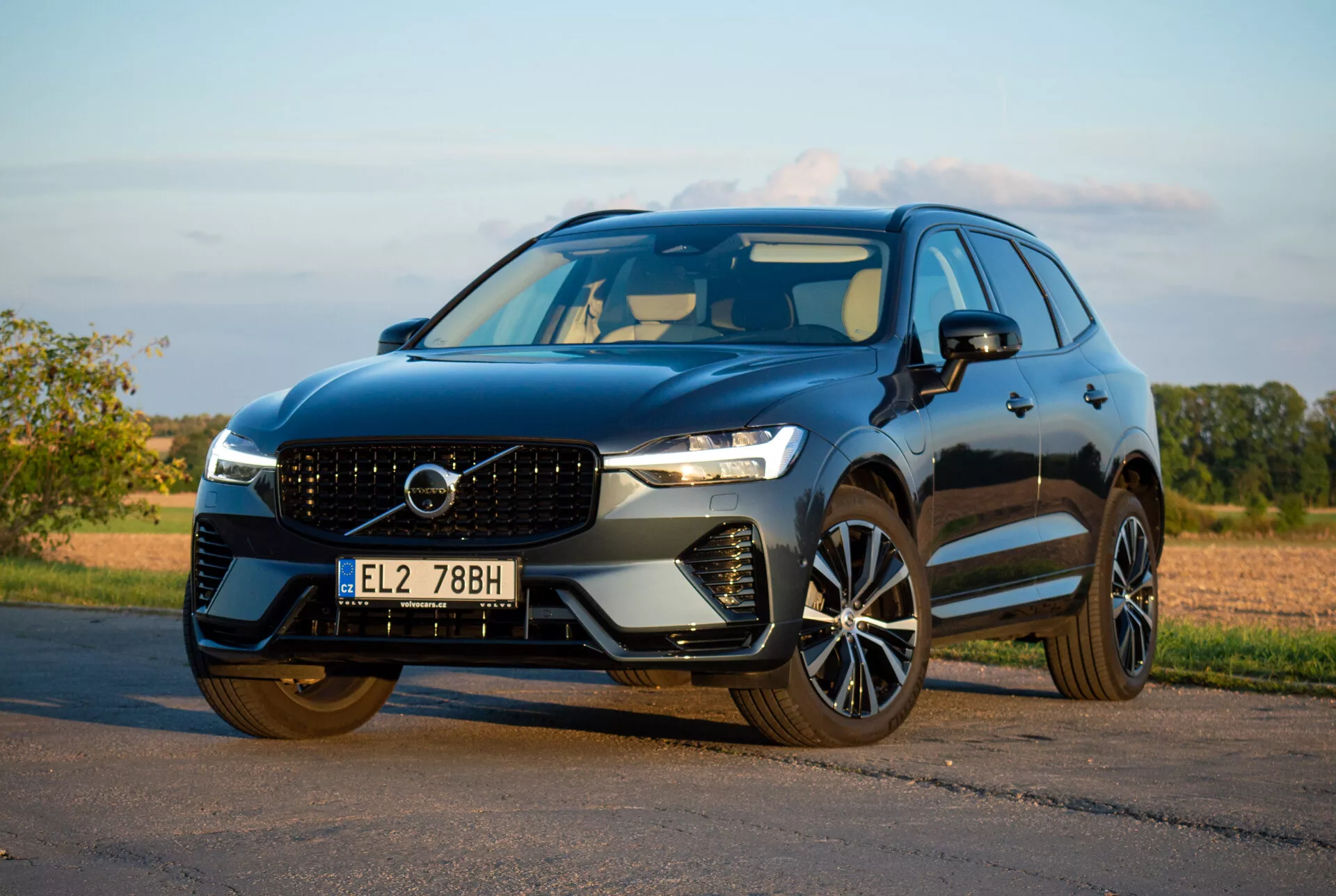 SUV Volvo XC60 Recharge Plug-In Hybrid 2021 garé sur l'asphalte, présentant son design élégant et ses fonctionnalités technologiques avancées depuis un angle avant bas de trois quarts
