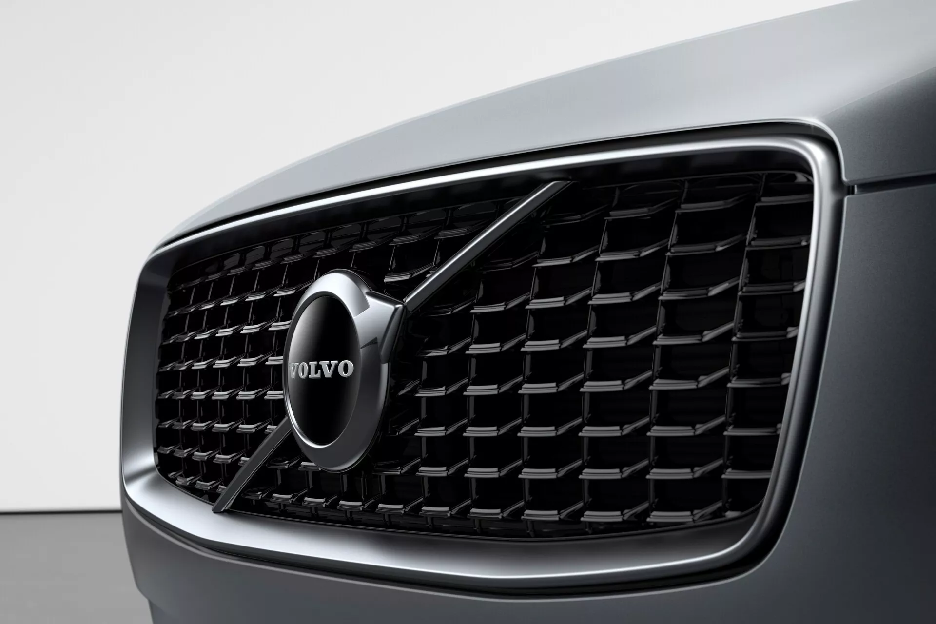 Vue rapprochée de la calandre avant d'une Volvo XC90 2015 (2e génération), mettant en valeur le design détaillé et l'emblème de marque Volvo proéminent. La calandre présente des lames verticales et un contour chromé, soulignant le luxe et l'esthétique moderne.