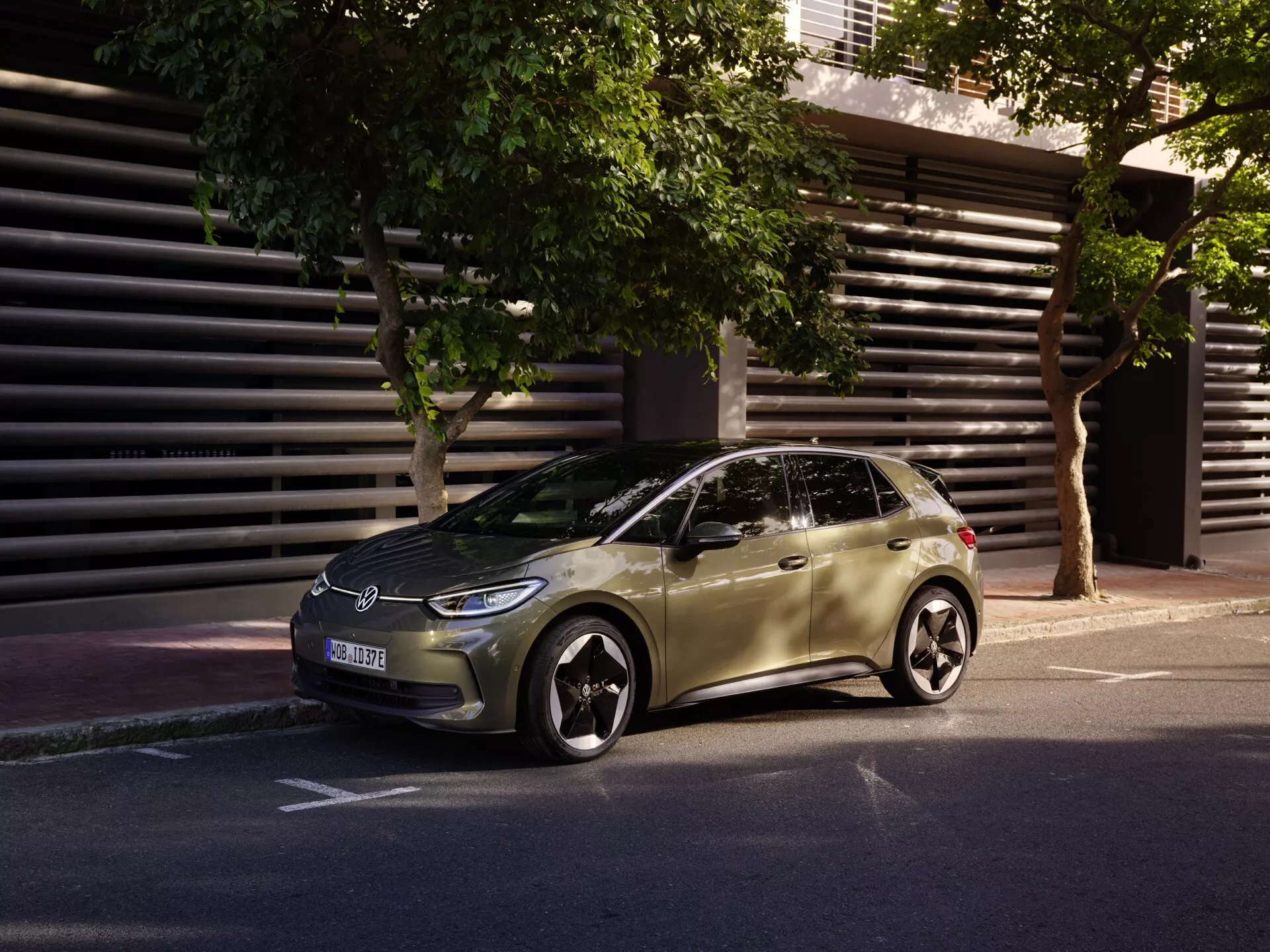 VW ID.3 1ère Génération Facelift Modèle 2023 - Hatchback élégant garé dans la rue urbaine en vue trois quarts avant mettant en avant les phares LED, les roues en alliage et la conception aérodynamique à la lumière du matin ou de l'après-midi