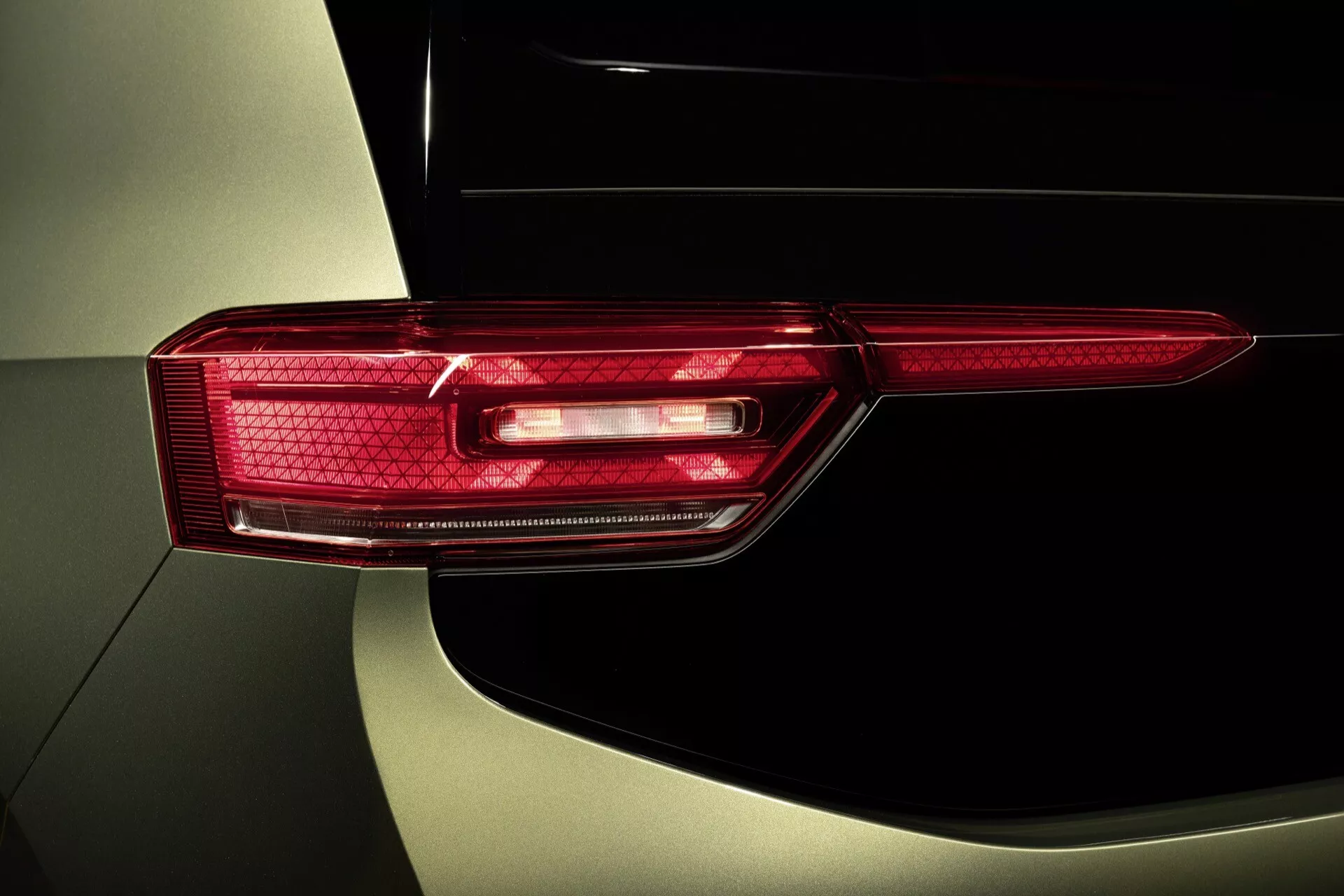 Modèle VW ID.3 2023 1ère génération avec face-lift montrant un gros plan détaillé du feu arrière avec technologie LED et un design horizontal moderne avec des motifs complexes, soulignant le système d'éclairage avancé du véhicule et la finition métallique de la carrosserie