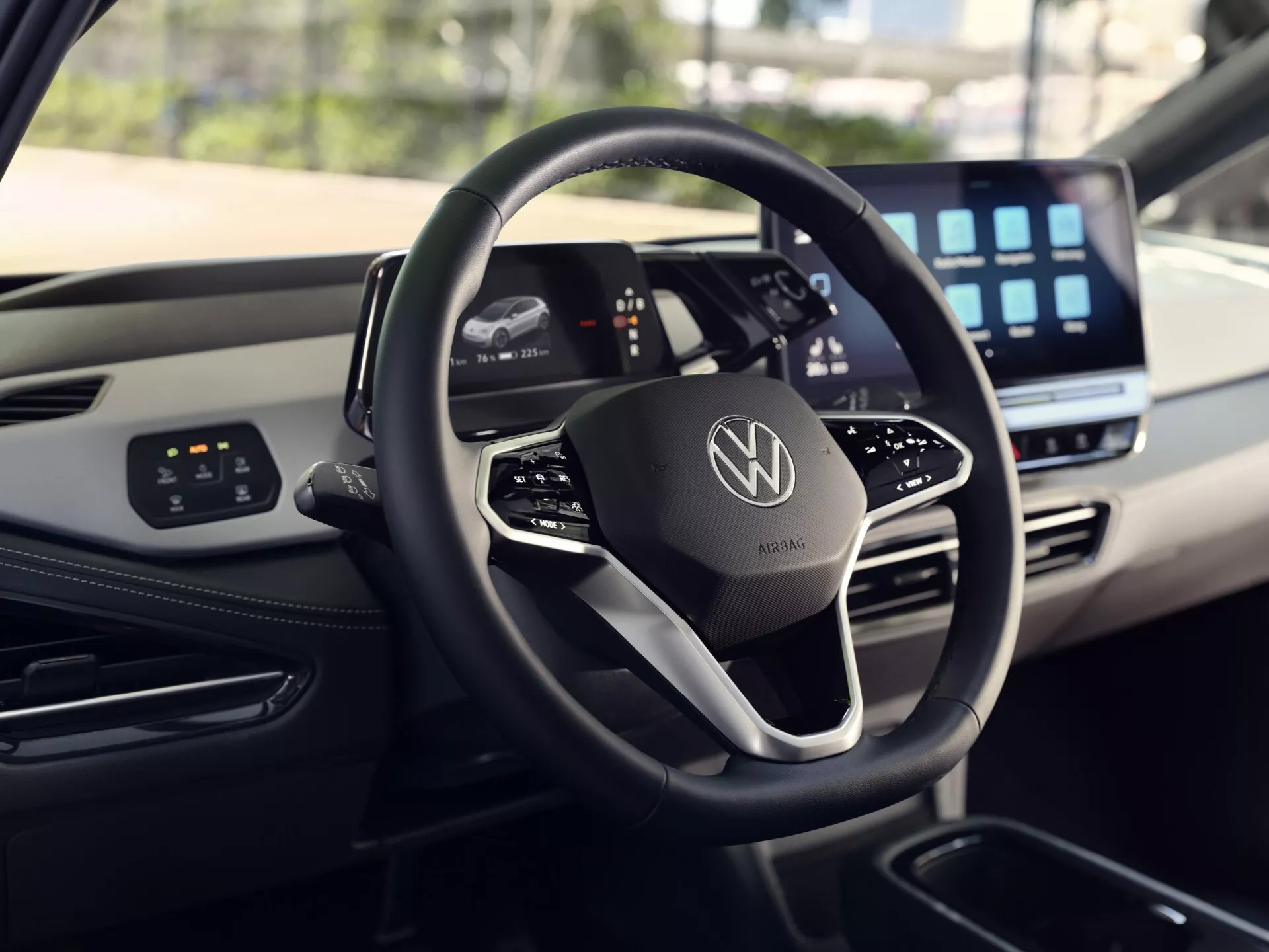 Vue intérieure du VW ID.3 1ère Génération facelift 2023 avec volant moderne à fond plat et emblème en chrome, tableau de bord numérique et grand écran d'infodivertissement, démontrant des systèmes de contrôle avancés et des éléments de design luxueux