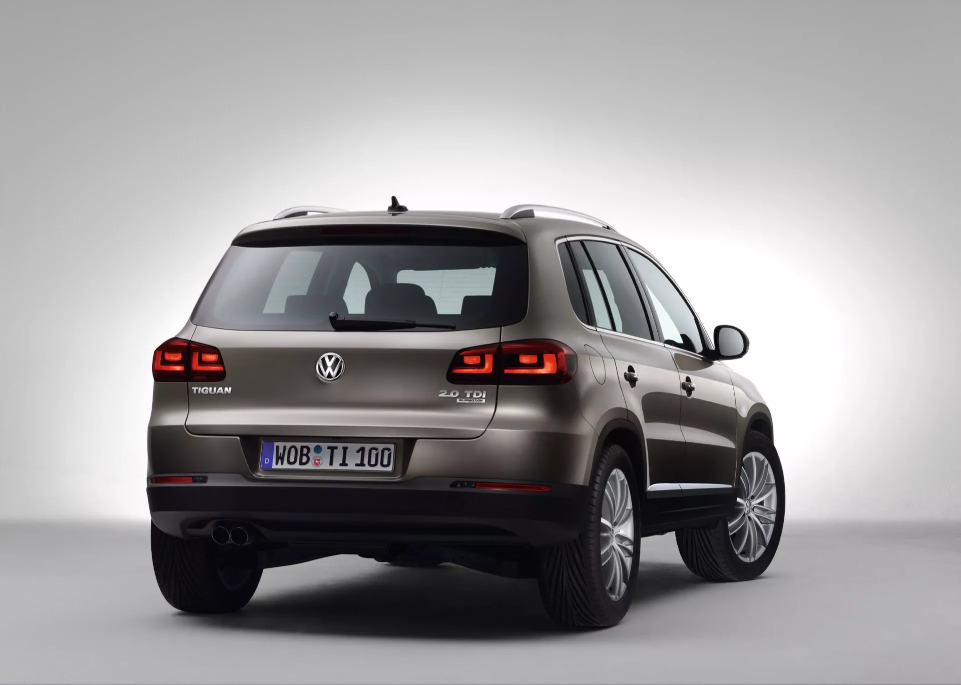 SUV Volkswagen Touareg en studio, angle arrière de trois quarts montrant le côté droit, l'arrière, les feux arrière à LED, l'insigne V6 TDI et les jantes en alliage à rayons multiples sur un fond dégradé