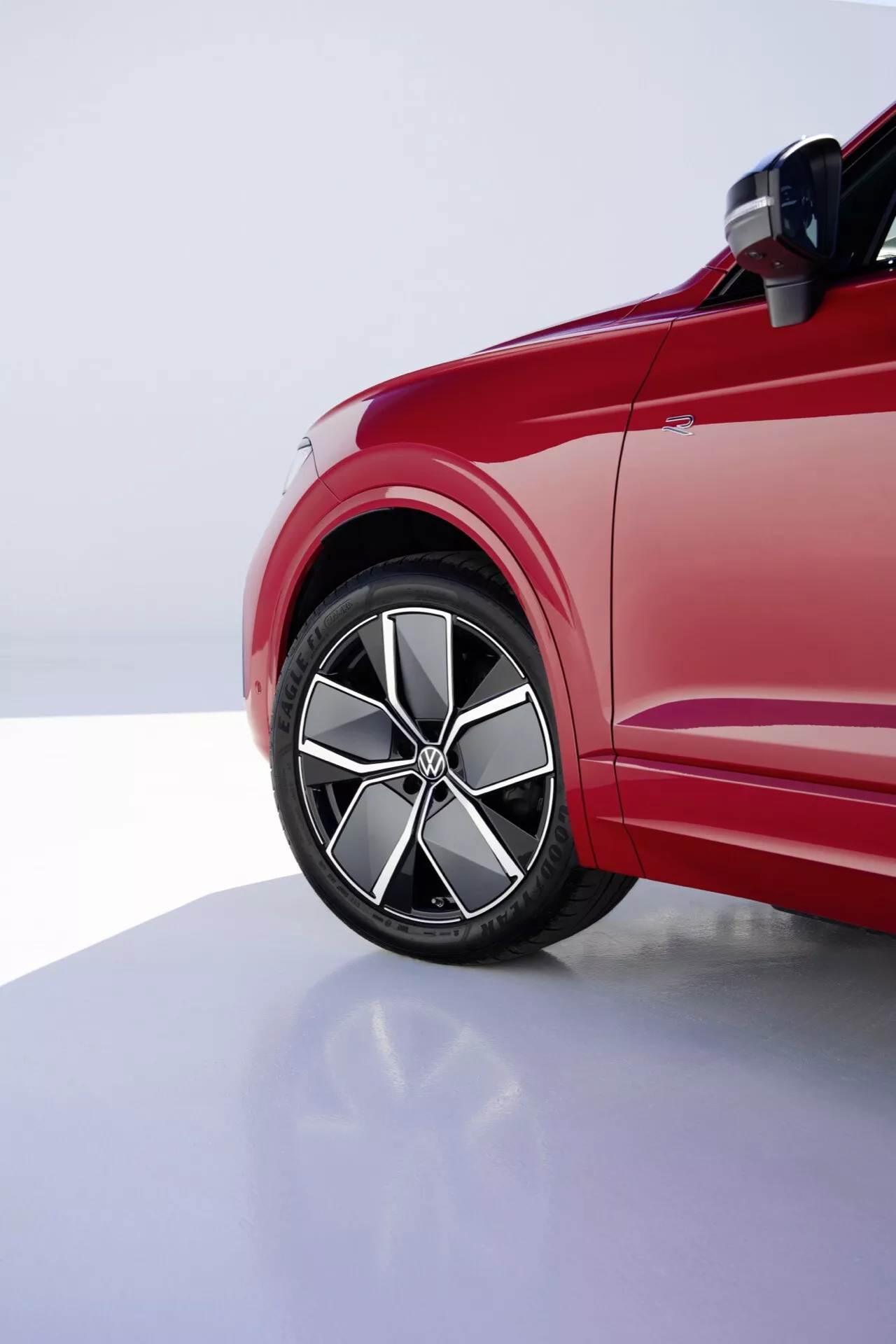Vue du quart avant côté conducteur de la VW Touareg Facelift 2023 mettant en lumière la roue en alliage, le pneu profil bas et les lignes dynamiques de la carrosserie sous un éclairage de studio professionnel