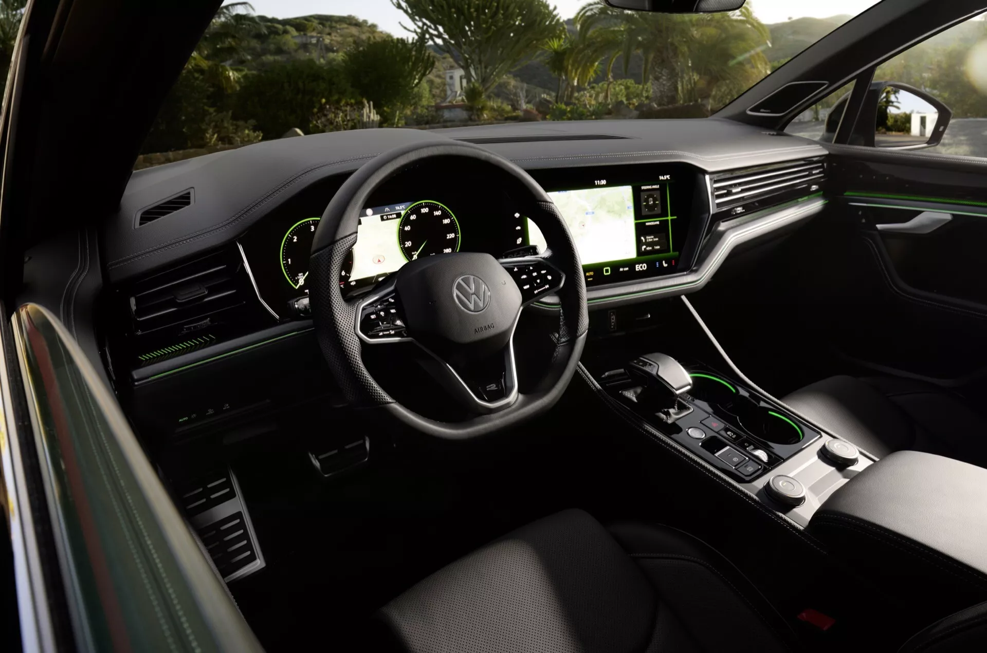 Vue intérieure de la Volkswagen Touareg 2023 depuis le siège arrière montrant le tableau de bord, les écrans numériques, le volant avec commandes intégrées, et la console centrale dans un design moderne et luxueux