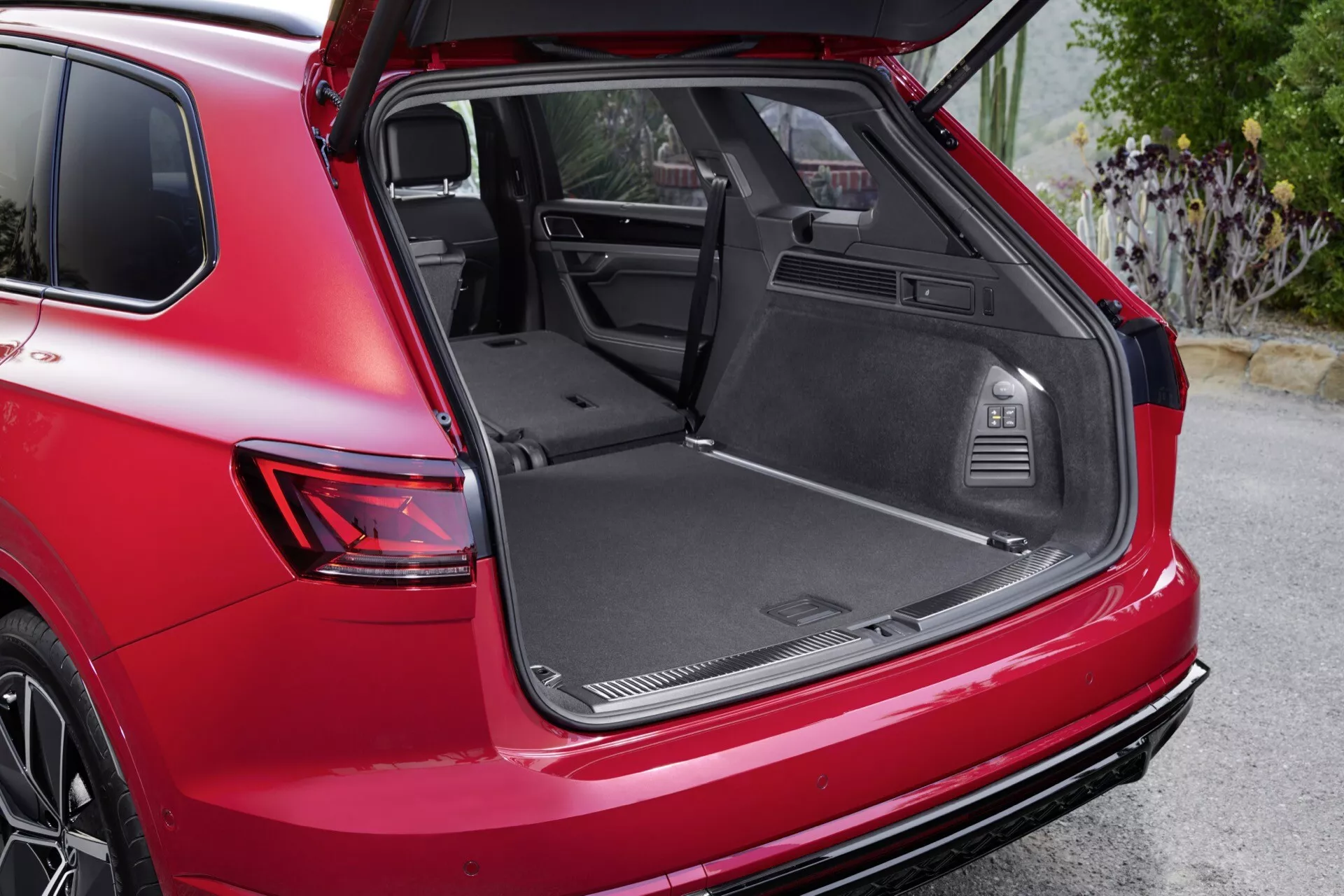 SUV VW Touareg Facelift 2023 présentant le coffre ouvert depuis une perspective arrière trois quarts mettant en évidence l'espace de chargement, l'intérieur premium et les éléments de design moderne, garé en extérieur