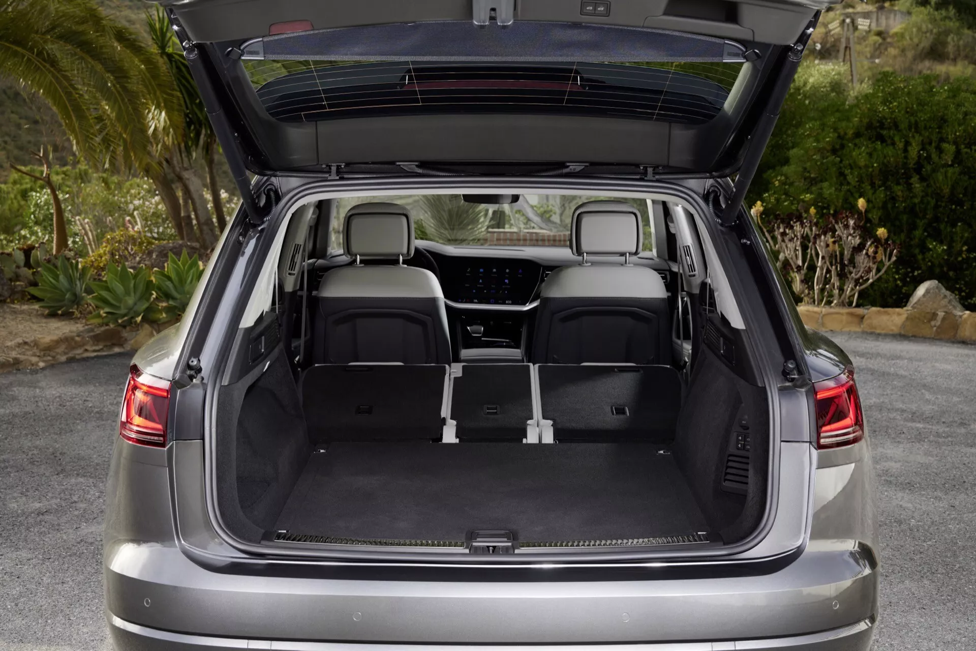 Section arrière du VW Touareg 2023 (III Facelift) avec coffre ouvert montrant un espace de chargement spacieux, sièges arrière rabattus, doublure intérieure de qualité et éclairage LED intégré conçu pour le confort et l'utilité