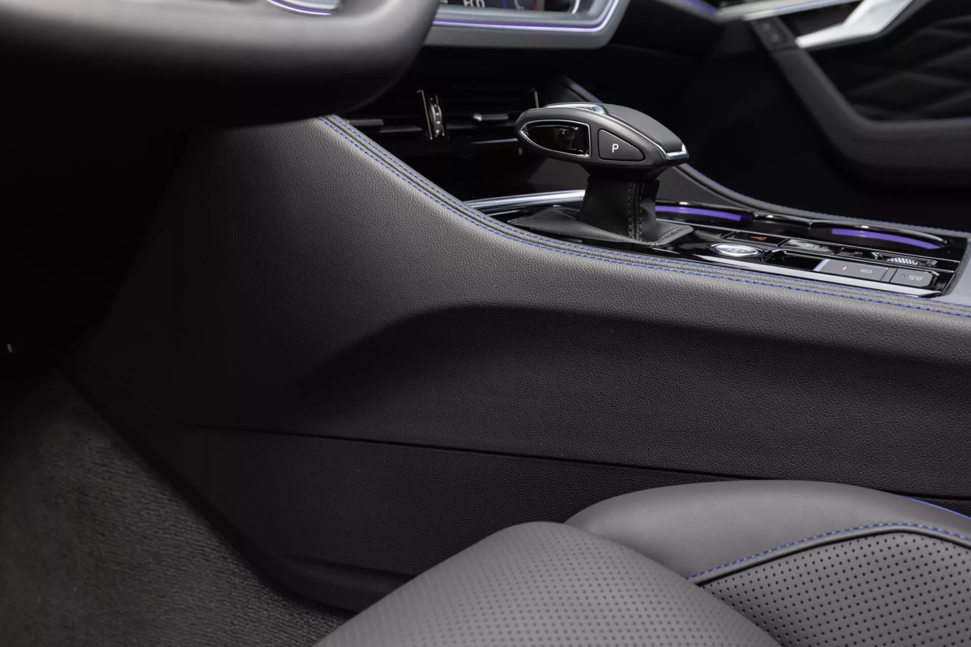 Détail intérieur de la Volkswagen Touareg 2023 mettant en évidence la console centrale, le levier de vitesse ergonomique de la transmission automatique, et les finitions premium en chrome, soulignant les commandes avancées de l'infodivertissement et les sièges à contrôle climatique