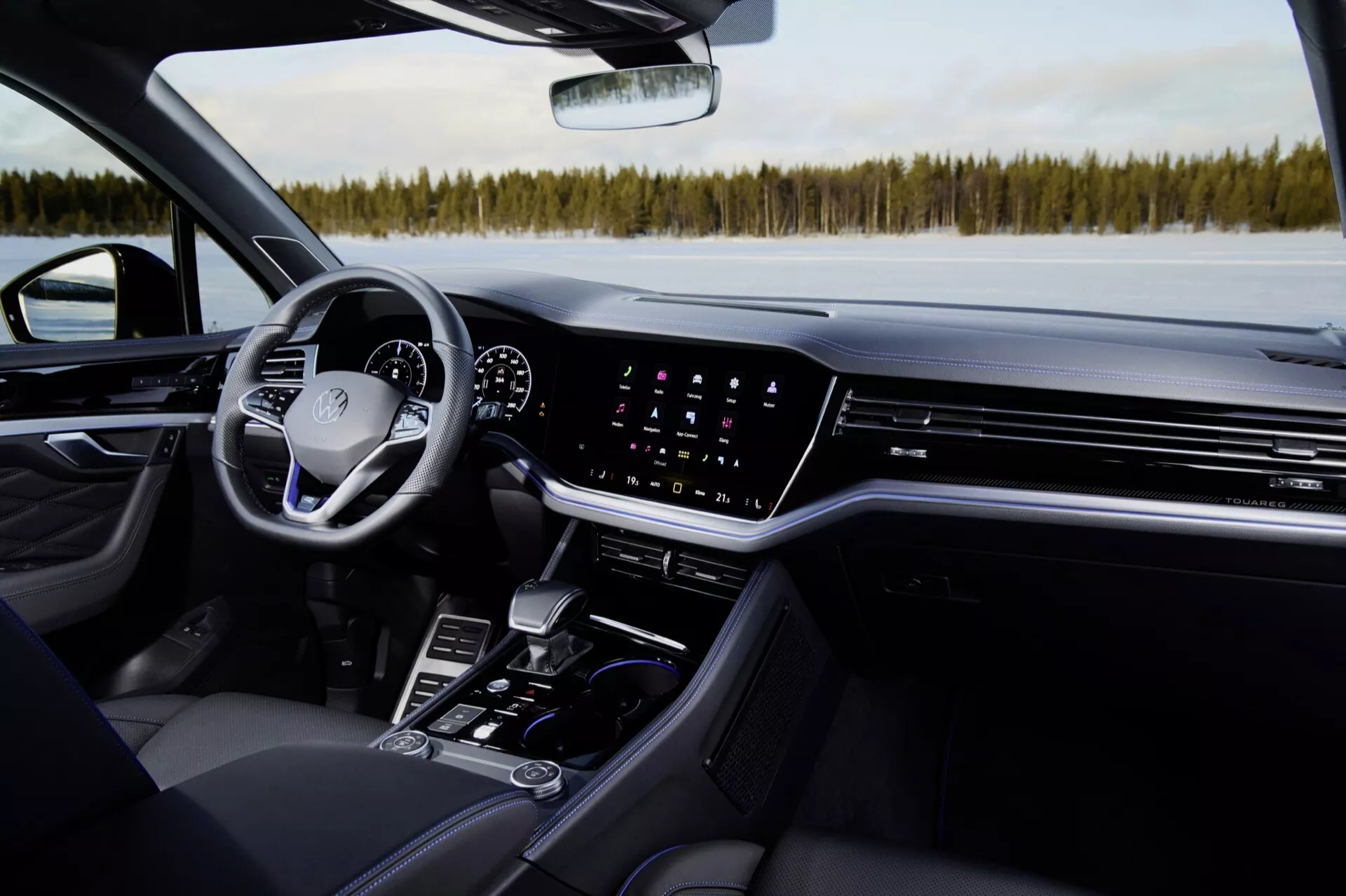 Vue intérieure du Volkswagen Touareg 2023 : Perspective du côté passager mettant en évidence le tableau de bord, l'écran tactile de l'infodivertissement, le contrôle du climat, le cluster d'instruments numérique, le volant multifonctionnel et les caractéristiques de la console centrale dans une automobile de luxe moderne